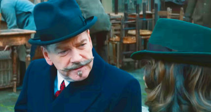 Hercule Poirot (Kenneth Branagh) is intrigued by Ariadne Oliver's (Tina Fey) story in A Haunting in Venice (2023), 20th Century Studios