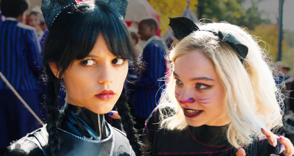 Wednesday (Jenna Ortega) and Enid (Emma Myers) emerge from the canoe race victorious in Wednesday Season 1 Episode 2 "Woe Is The Loneliest Number" (2022), Netflix