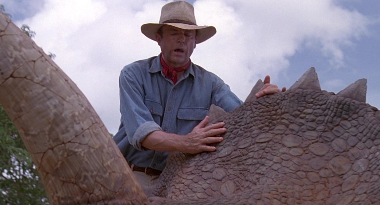 Dr. Alan Grant (Sam Neil) feels the skin of a dinosaur for the first time in Jurassic Park (1993), Universal Pictures