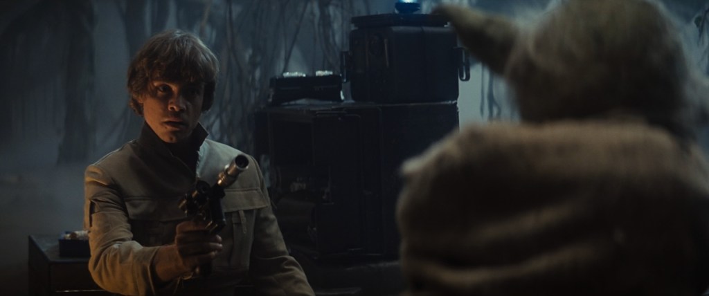 Luke Skywalker (Mark Hamill) points his blaster at a Dagobah local in Star Wars Episode V: The Empire Strikes Back (1980), Lucasfilm