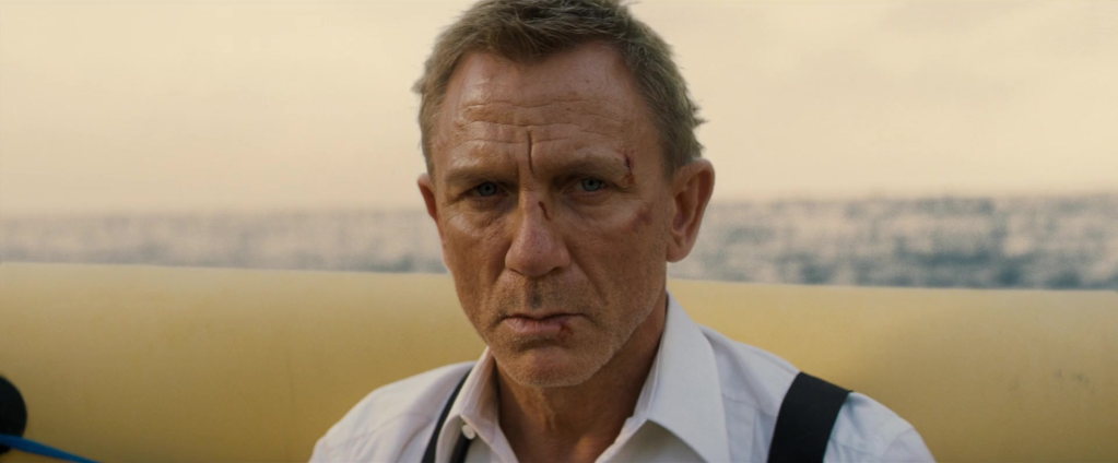 James Bond (Daniel Craig) survives Ash's (Billy Magnussen) attempt to blow him up in No Time To Die (2021), MGM
