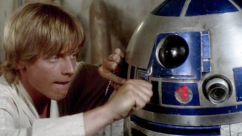 Luke Skywalker (Mark Hamill) attempts to fix his newly-purchased R2 unit (Kenny Baker) in Star Wars - Episode IV: A New Hope (1977), Lucasfilm