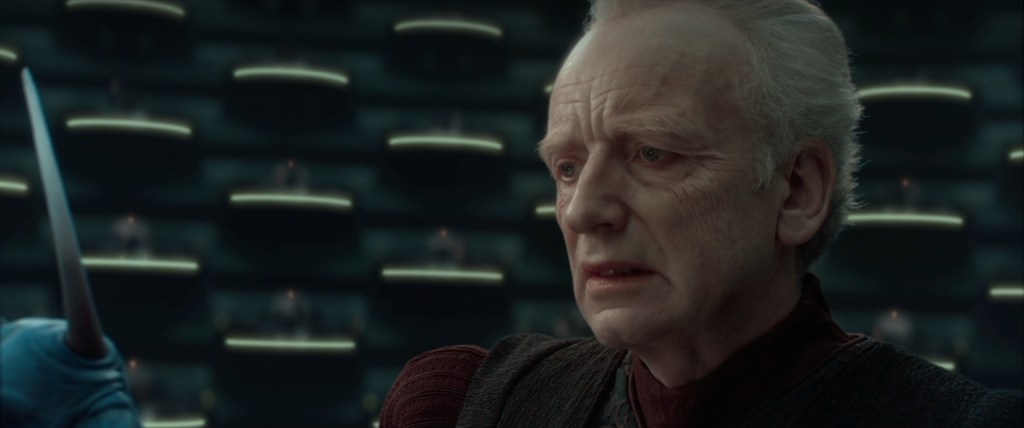 A reluctant Supreme Chancellor Sheev Palpatine (Ian McDiarmid) accepts the Emergency Powers he's been granted in Star Wars Episode II: Attack of the Clones (2002), Lucasfilm Ltd.