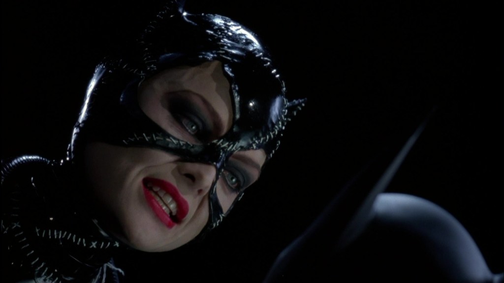 Catwoman has Batman pinned down in Batman Returns (1992), Warner Bros. Pictures