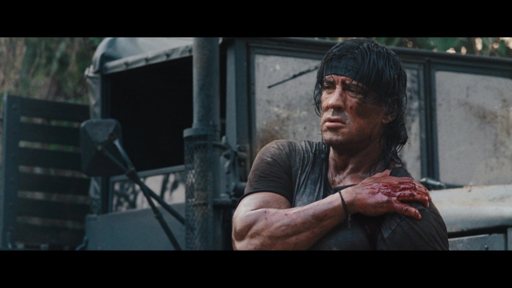 Rambo (Sylvester Stallone) emerges victorious from his fight with Tint (Maung Maung Khin) and his men in Rambo (2008), Millennium Media