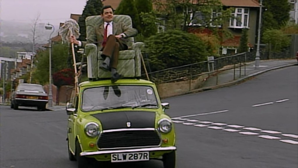 Mr. Bean (Rowan Atkinson) drives his new couch home in Mr. Bean Episode 9 "Do-It-Yourself Mr. Bean" (1994), Tiger Aspect Productions