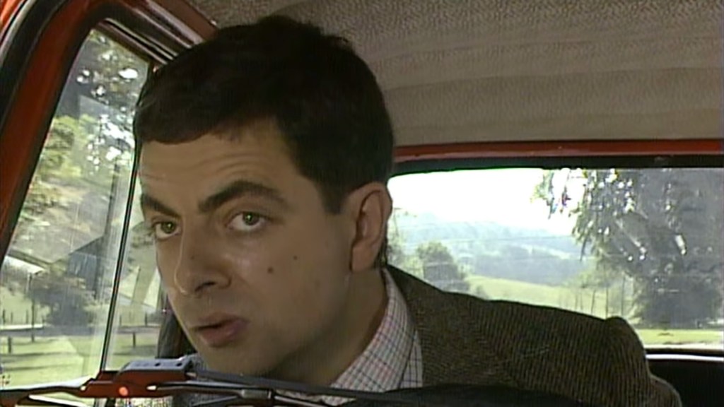 Mr. Bean (Rowan Atkinson) is annoyed by the three-wheeled blue car in Mr. Bean Episode 1 "Mr. Bean" (1991), Tiger Aspect Productions