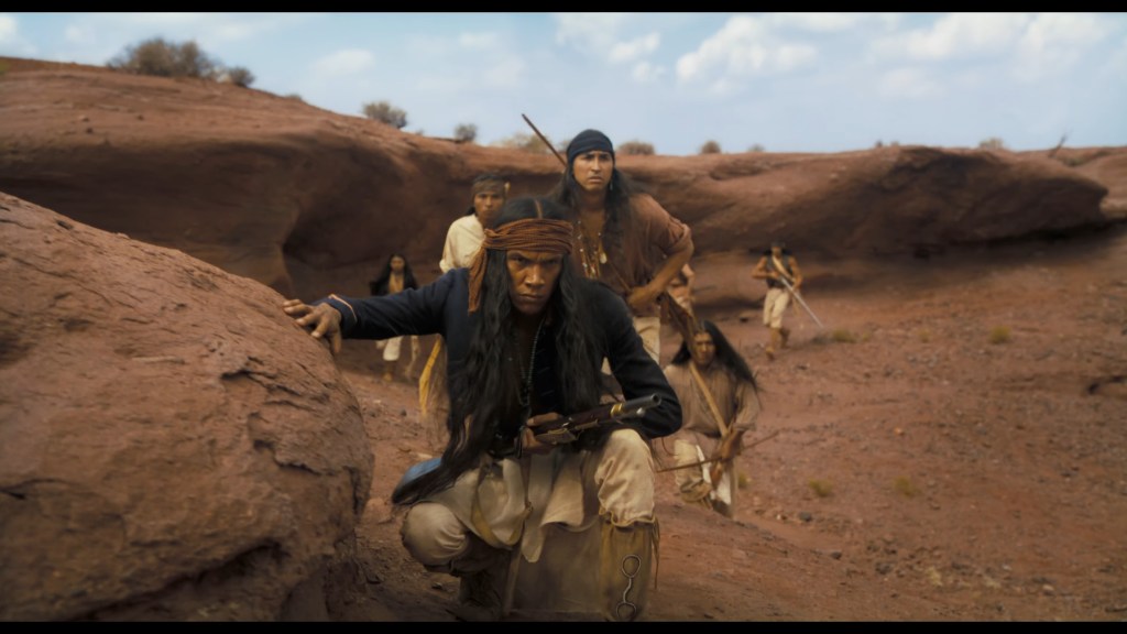 A Native American resistance fighter (Tatanka Means) prepares to ambush a group of settlers in Horizon: An American Saga (2024), New Line Cinema
