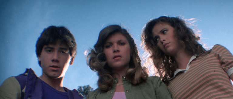 Andy, (Jeffrey Rogers), Chris (Dana Kimmell), and Debbie (Tracie Savage) come across a man lying in the middle of the road in Friday the 13th: Part III (1982), Paramount Pictures