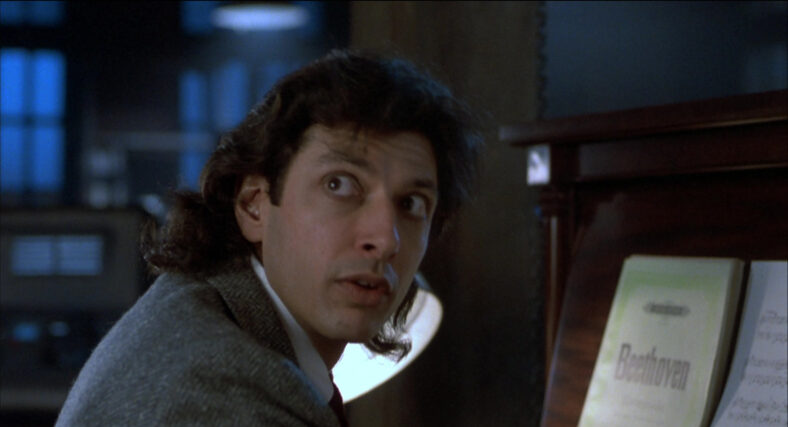Seth Brundle (Jeff Goldblum) tries to hit the right notes but doesn't like what he's hearing in The Fly (1986), 20th Century Studios