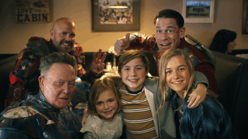 Blue Dragon (Robert Patrick), Captain Triumph (David Denman), and Peacemaker (John Cena) pose for a selfie with some adoring fans in Peacemaker Season 2 Episode 6 "Ignorance is Chris" (2025), DC Studios