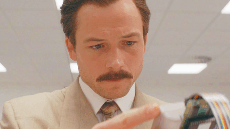 Henk Rogers (Taron Egerton) tests out the Nintendo Game Boy version of the titular game in Tetris (2023), Apple