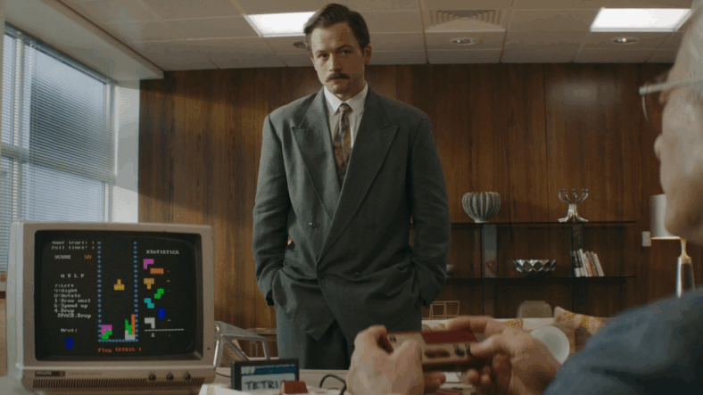 Henk Rogers (Taron Egerton) waits with baited breath as Nintendo President Hiroshi Yamauchi (Togo Igawa) tries out the titular game in Tetris (2023), Apple