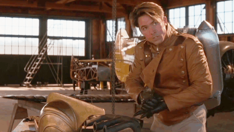 Cliff (Billy Campbell) suits up to save Malcom (Eddie Jones) from a potential plane crash in The Rocketeer (1991), Walt Disney Pictures